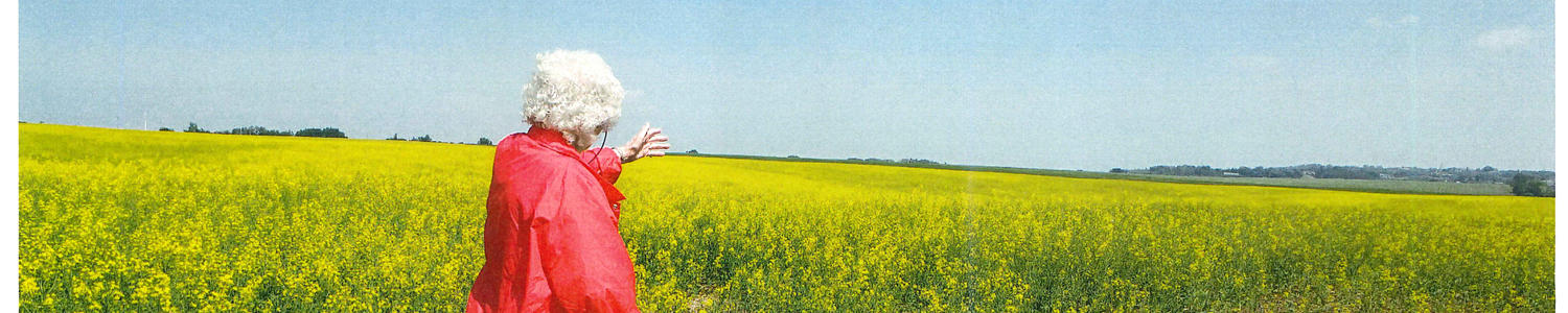 Joan in a field looking at flowers