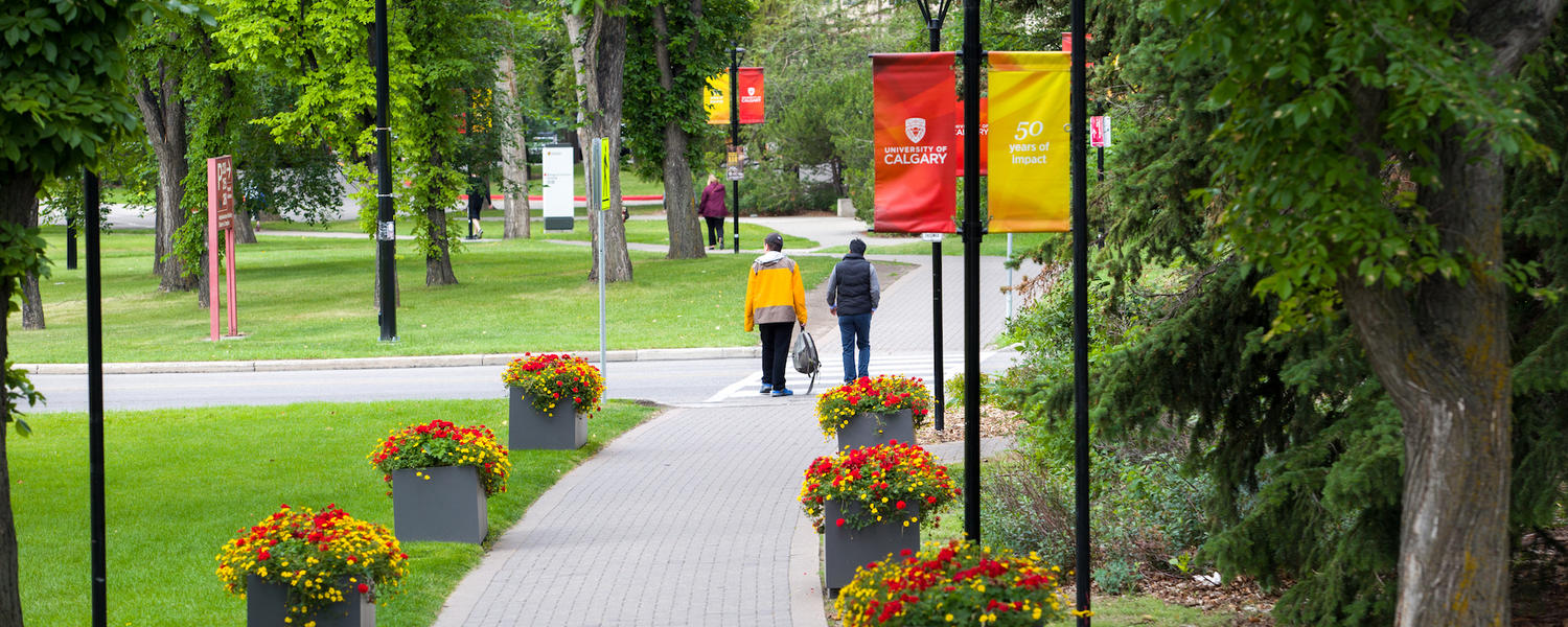 student crossing the street on campus in the summer