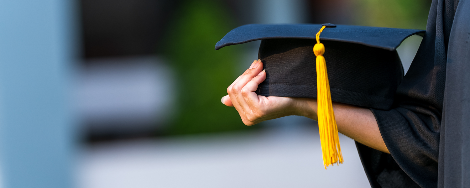 hand holding a mortarboard 