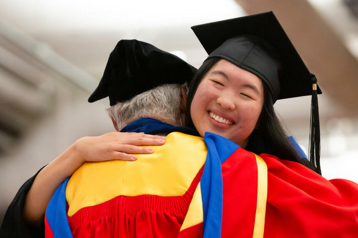 Emily Chen embraces Dick Haskayne at the 2023 convocation ceremony.