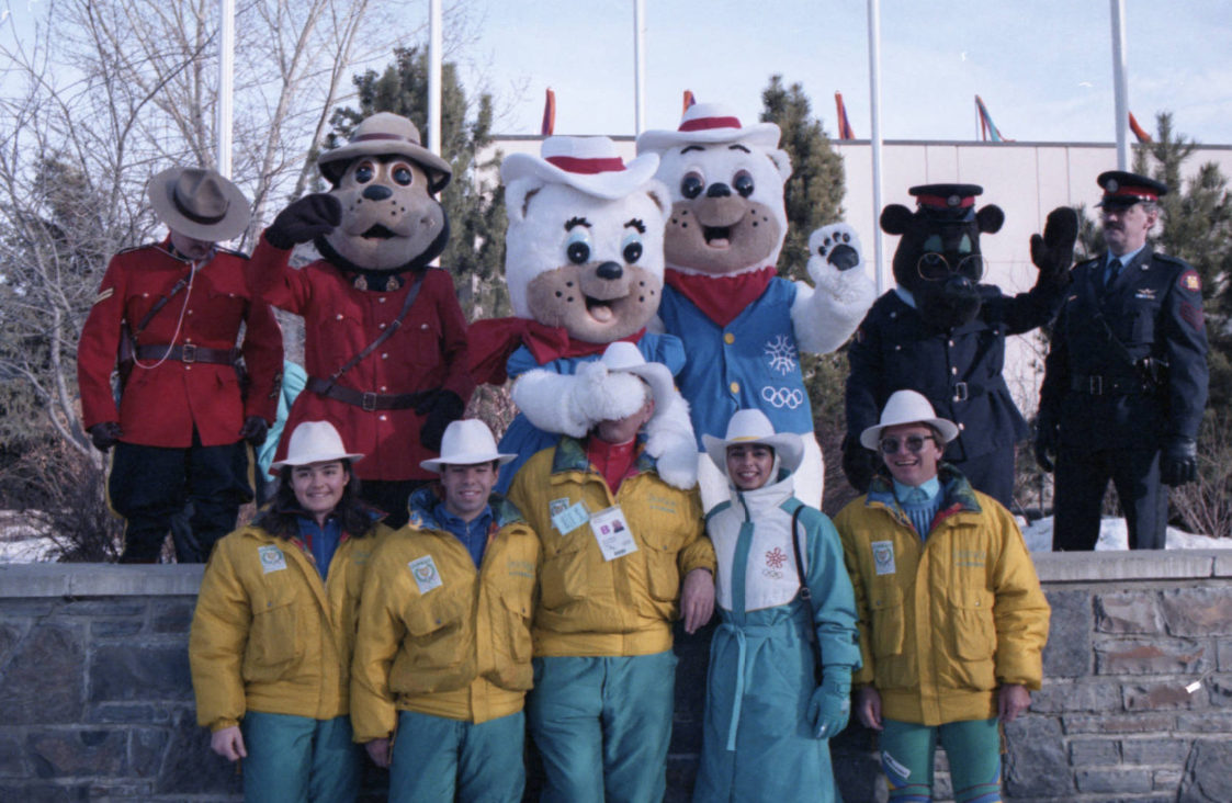 Image of Cypriot Olympic athletes with the 1988 Calgary Winter Olympic mascots Hidy and Howdy during the official ceremony to welcome athletes to the Olympic Village at the University of Calgary.