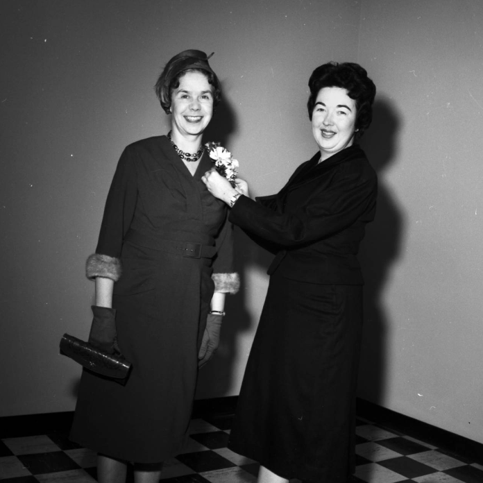 Image of Ethel M. King, advisor to women students and assistant professor of education, right, arranging a gift corsage for Phyllis Ford, wife of Chief Justice Clinton J. Ford, before the ceremonies to open the Arts and Education building.
