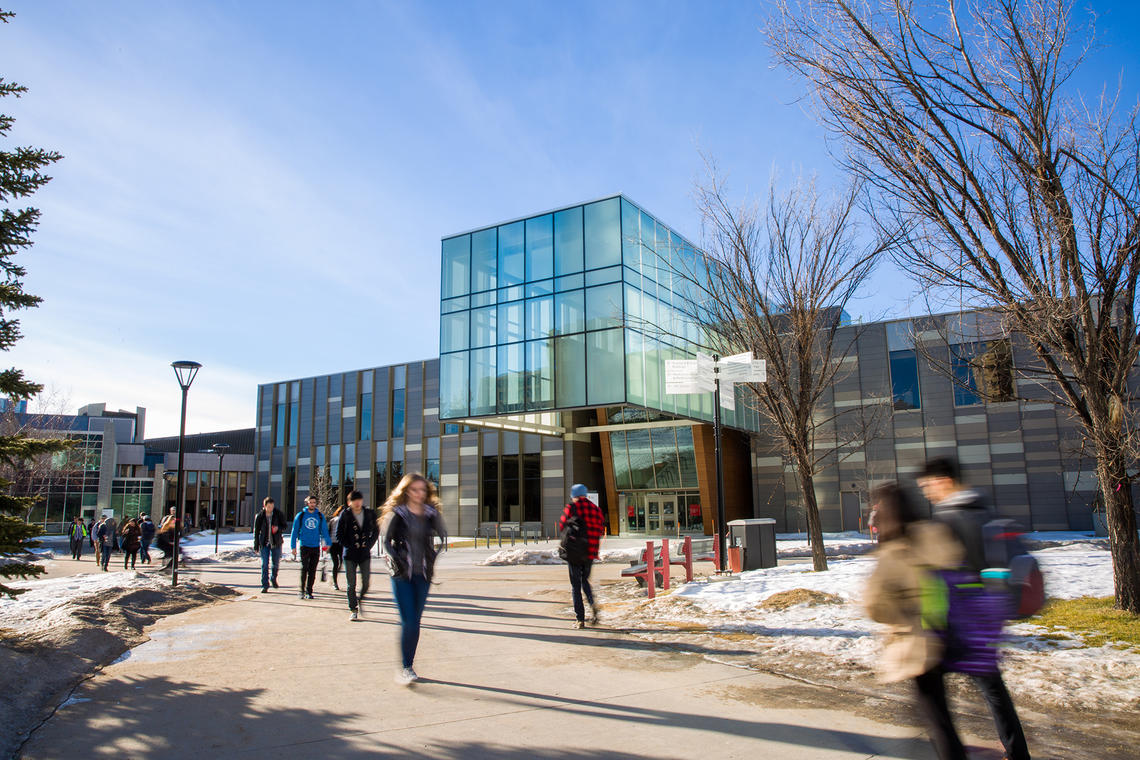 Student walking by the Teaching and Learning Centre at UCalgary