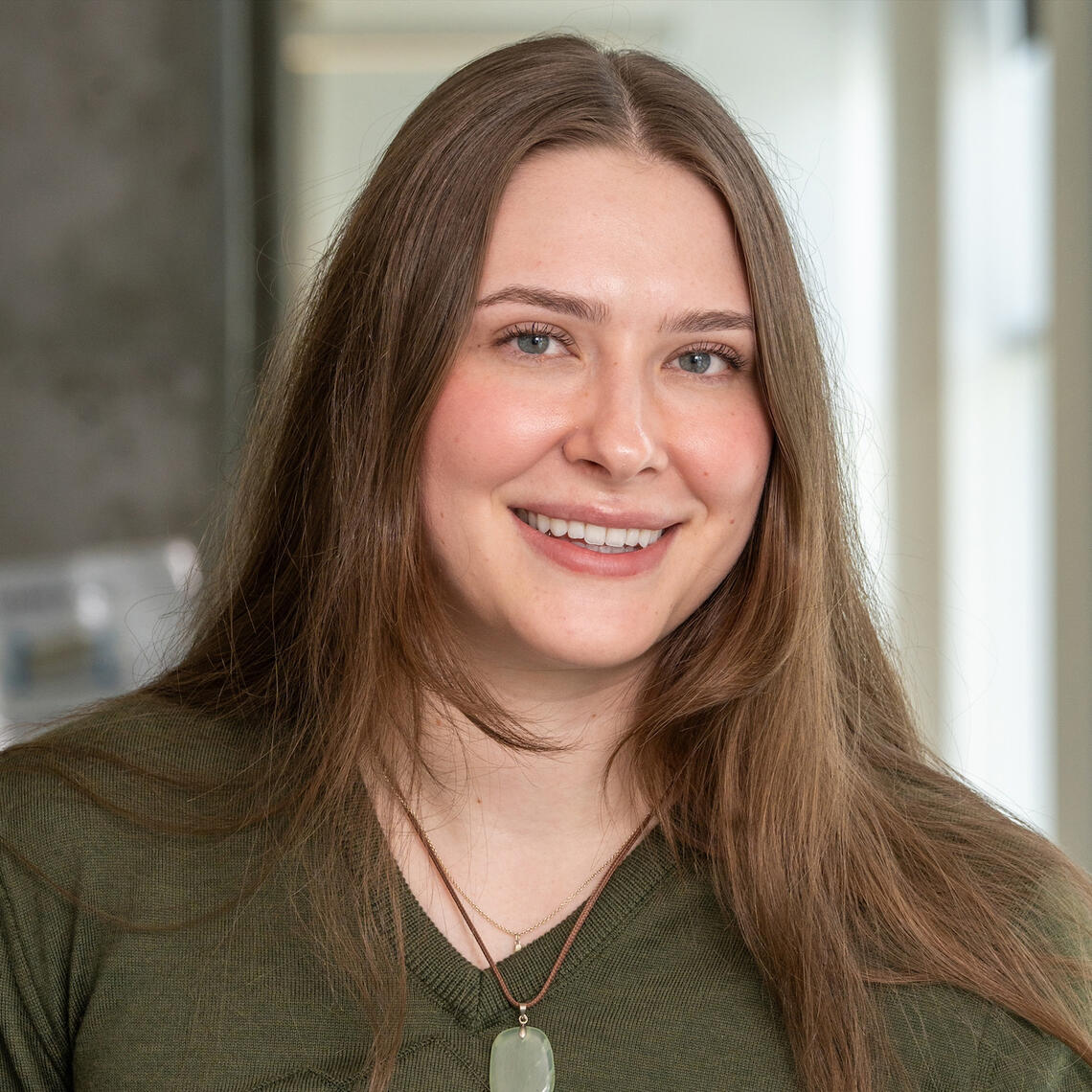 A woman with long brown hair smiling at the camera