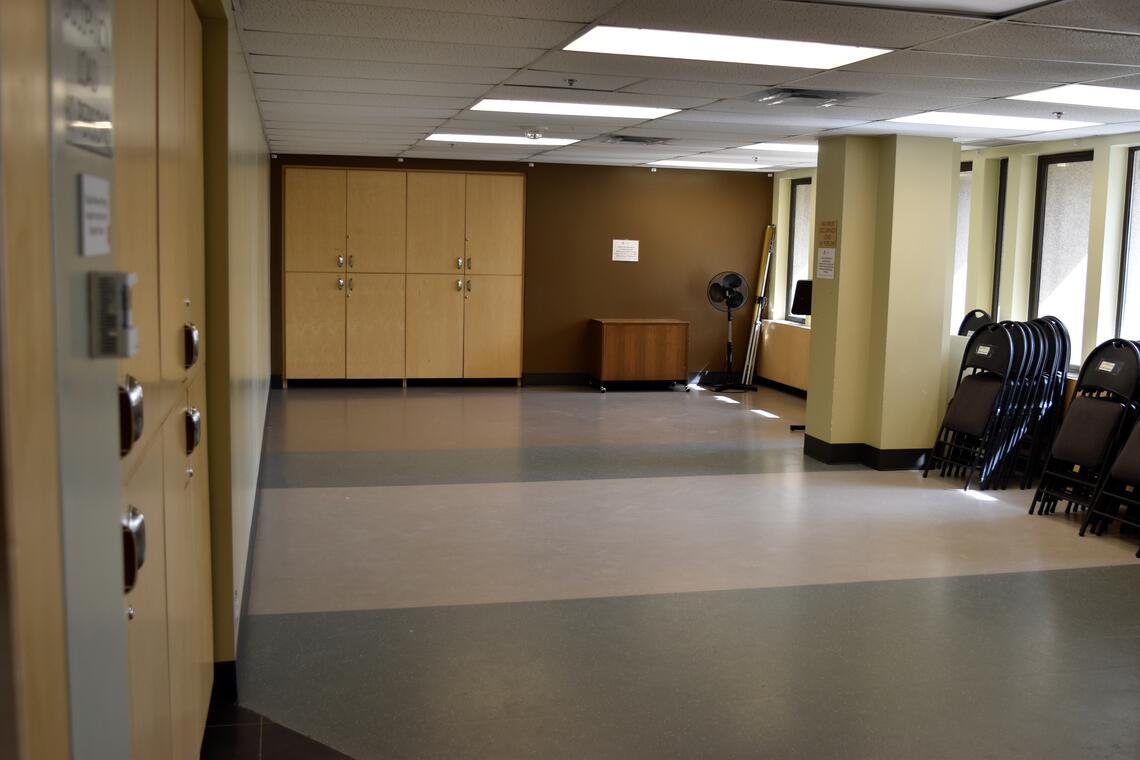 empty room with cabinets, windows, and chairs at the side