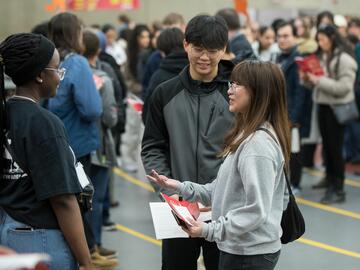 Orientation leader engaging with newly admitted students and parents at the You at UCalgary event.