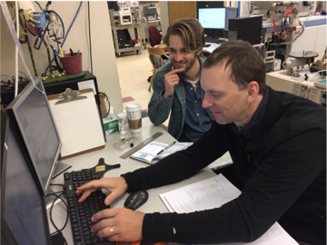 Two men working at a computer.