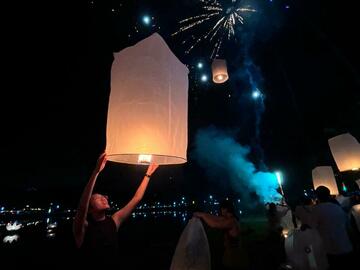 Candle inside a lantern being released to the dark night sky