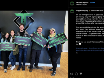 The team holding silly and celebratory signs at an escape room.