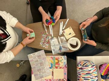 A group of students sit around a table with sensory tools.