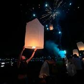 Person holding paper lantern to the dark sky