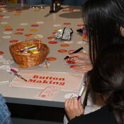 A group of students decorate First Gen Buttons.