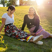 Two Indigenous students sitting on the grass