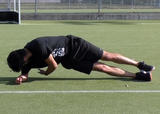 Athlete performing a side plank with torso rotation