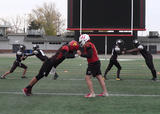 Football athletes performing standing partner push-ups