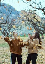 two girls throwing leaves in the air