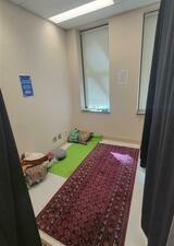 room with a carpet, meditation cushions, and windows