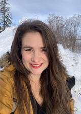 Image of Dr Engel in a yellow parka with a snowy background