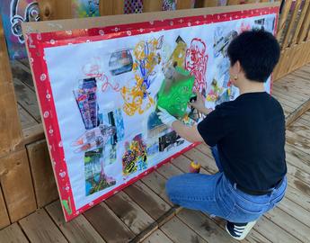 Land Acknowledgment Project participant practicing stencil graffeti. 