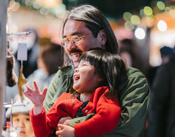 A father is shopping at Holiday market with his two daughters.