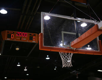 Basketball goal and score board in the background with a new game about to start.