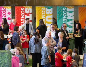 People mingle in a room with banners behind them