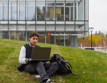 Student sitting outside on a laptop studying